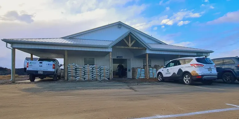 A building with a covered entrance and a parked white SUV.