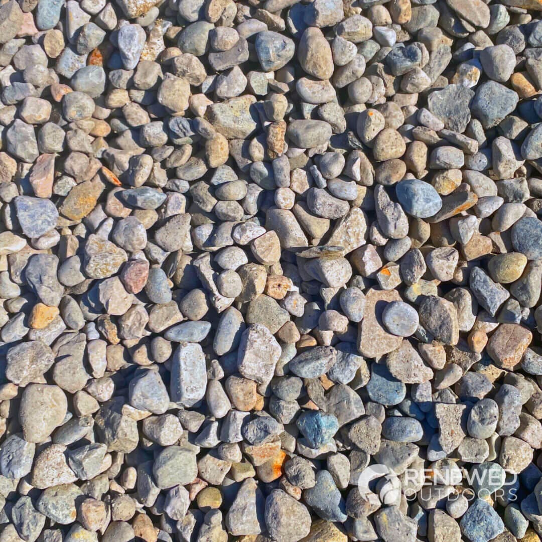Pebbles beneath clear water in sunlight.
