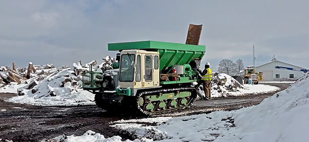 Tracked vehicle on snowy logging site.