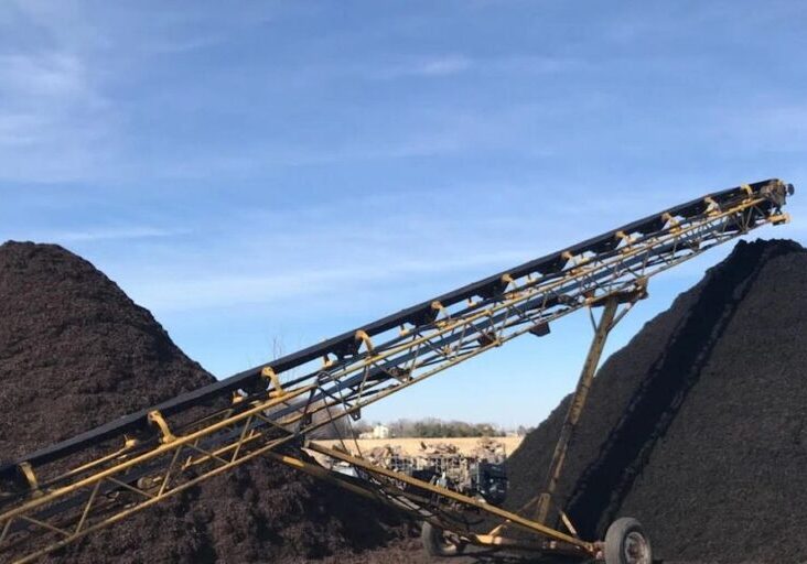 Industrial conveyor belt transporting materials at a mining site.